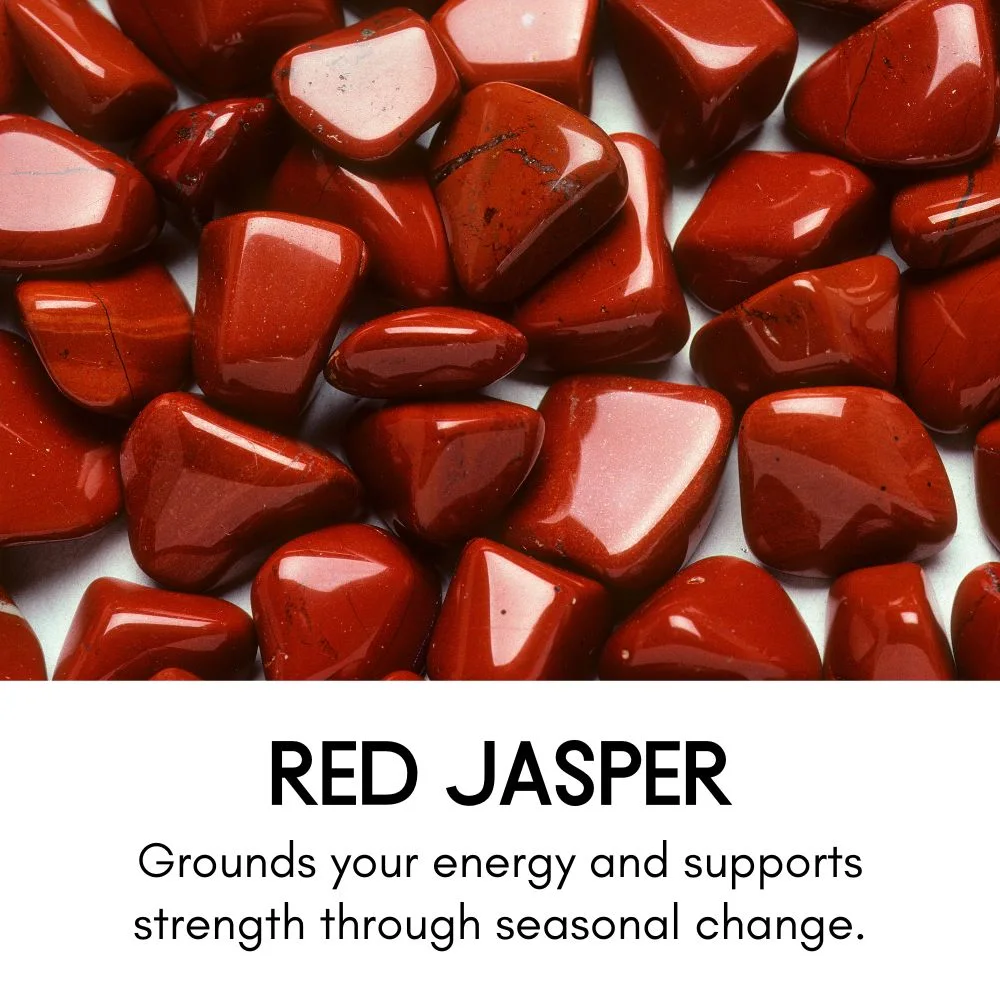 Collection of polished red jasper stones with a deep, rich red hue. Text below reads: 'Red Jasper – Grounds your energy and supports strength through seasonal change.'